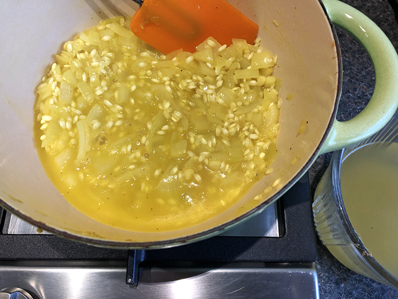 Wilde spinazie door een gele risotto