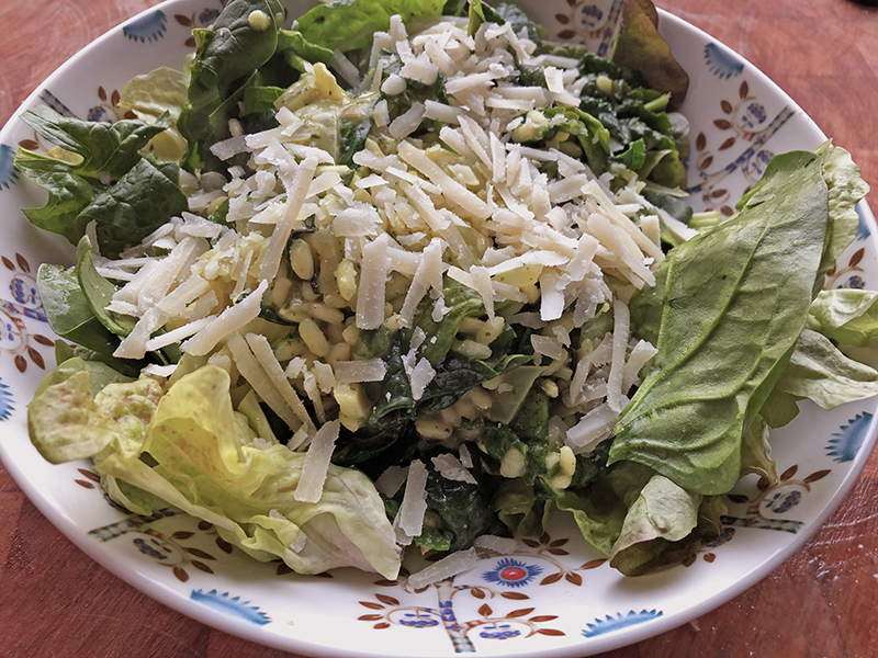 Wilde spinazie door een gele risotto