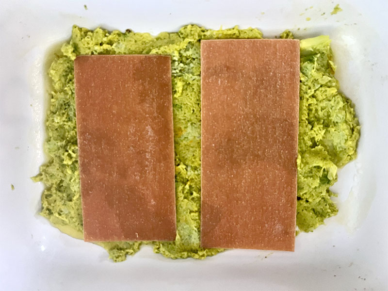 Groene kool met broccoli gepureerd in een linzen lasagne schotel